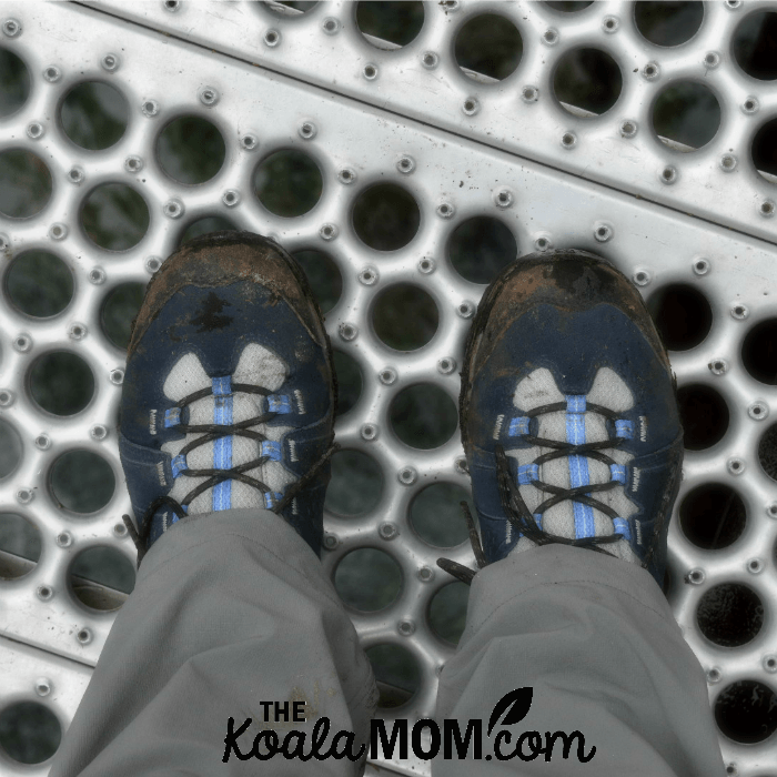 Hiking boots on a metal bridge.