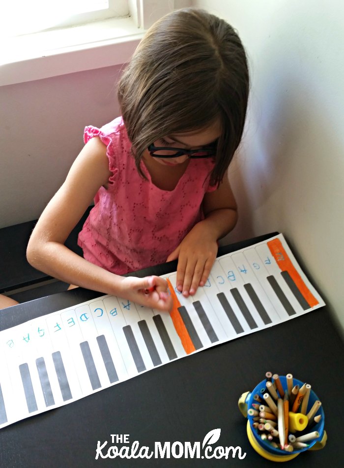 6-year-old colouring her paper piano.