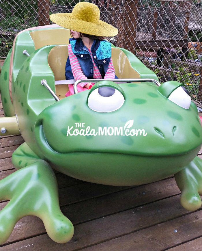 Girl riding on an amusement park frog.