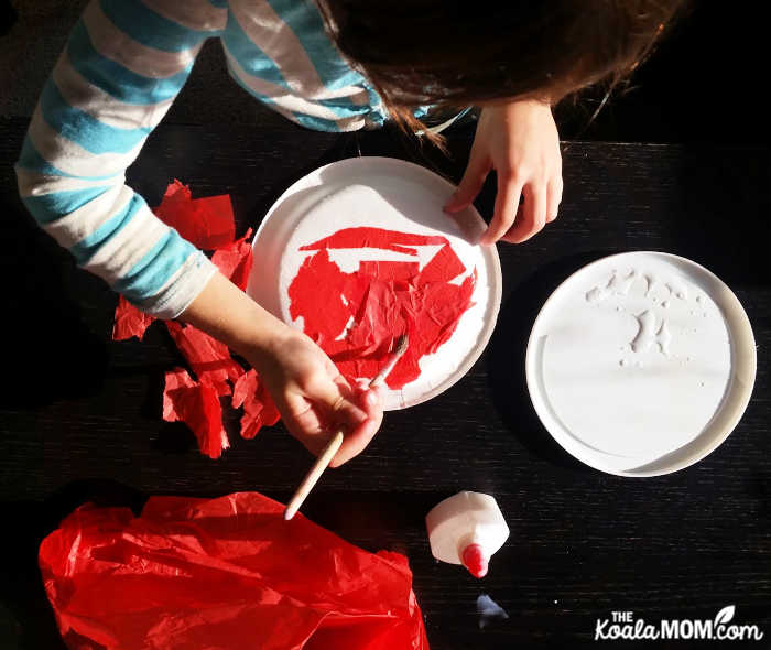 Grade 1 student making an Eric-Carle style ladybug craft for science.