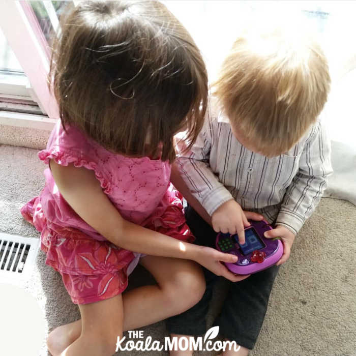 6-year-old and 2-year-old playing on an electronic learning system together.