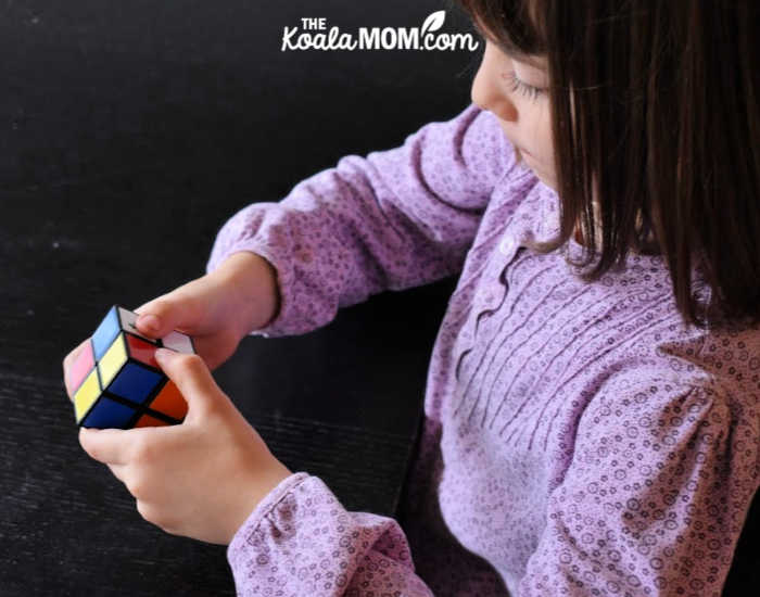 Six-year-old works on solving a cube puzzle.