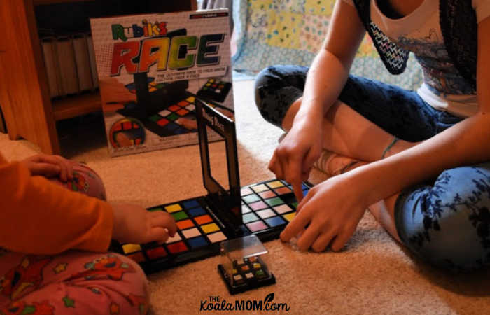 Preschooler and her sister play Rubik's Race together.