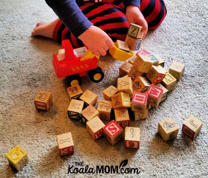 Toddler playing with his alphabet blocks.