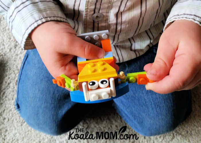 Two-year-old boy playing with his Lego robot minifigure.