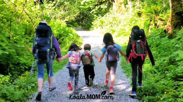 Five kids hiking together with their backpacks on.