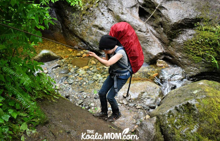 10-year-old Lily uses a rope to navigate a rocky ravine.