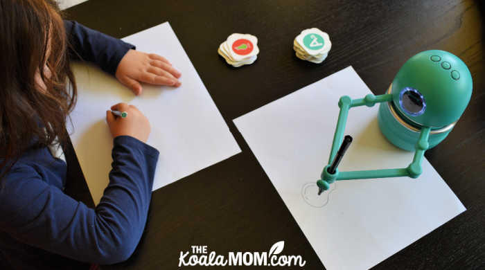 Robot teaching a preschooler how to draw a picture.