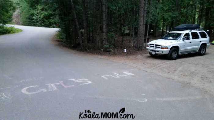 "GIRLS RULE" in sidewalk chalk on the pavement in front of our campsite.