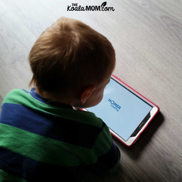 Toddler using HOMER Reading app on his tablet.