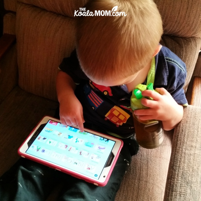 Toddler playing an educational phonics app on his tablet.