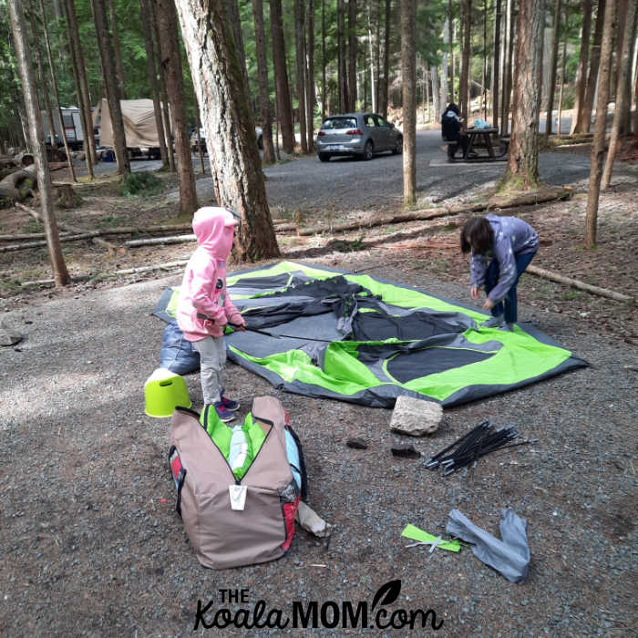 10-year-old and 8-year-old help take down the tent.