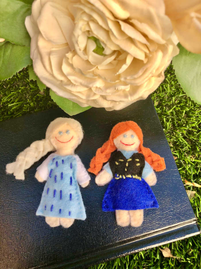 Madeleine makes custom felt princess dolls, like these Cinderella and Merida dolls.