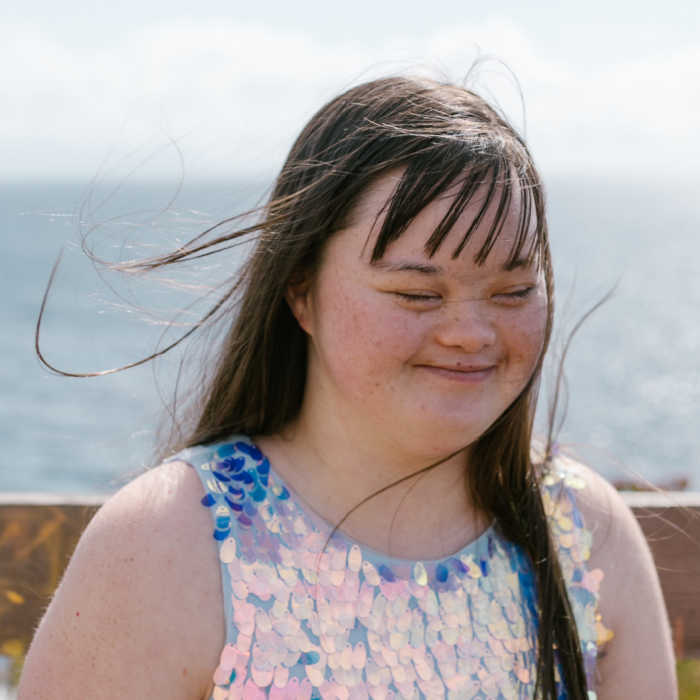 Girl on beach, with hair blowing in the wind.