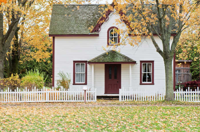 Neat white country home has good curb appeal with a trim yard, fresh paint, and clean windows.