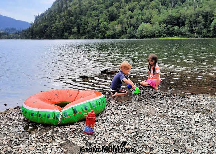 Kids playing near a floatie toy on a beach.