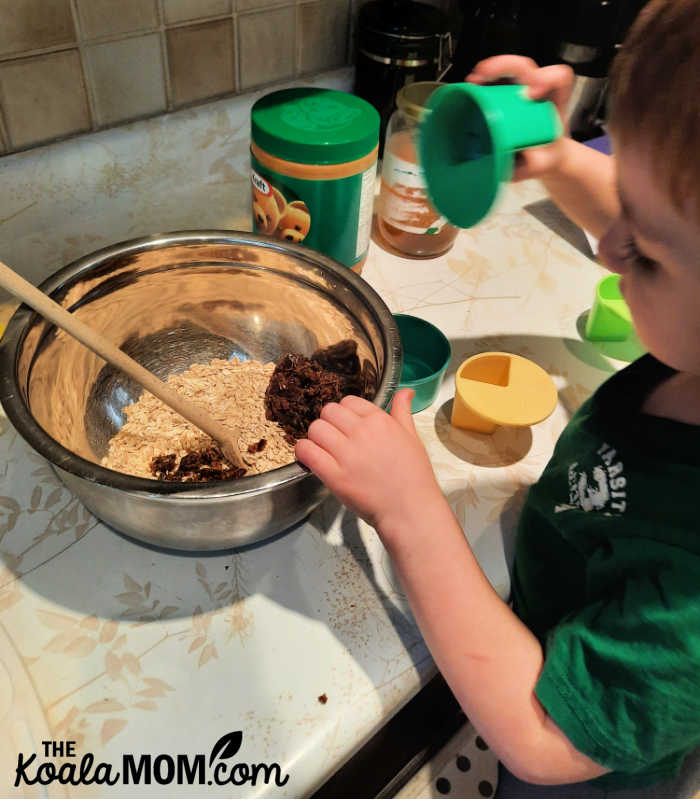 4-year-old measures ingredients for granola bars.