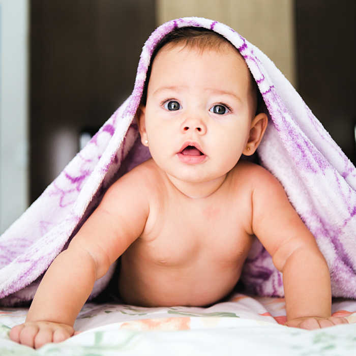 Baby under a blanket. Photo by Jonathan Borba on Unsplash,