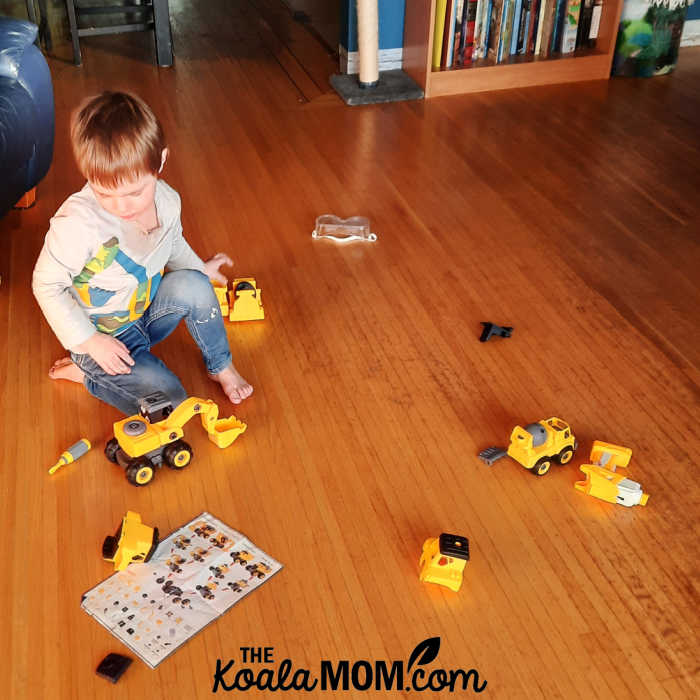 Joey playing with his construction truck toys.