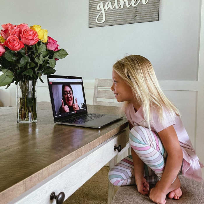 Smiling girl learning Spanish online via an iPad.