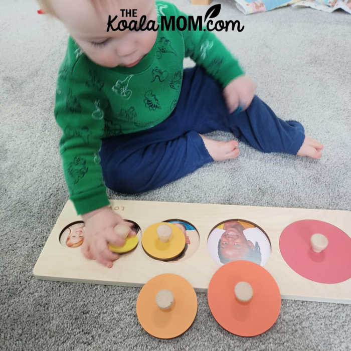 One-year-old playing with Lovevery Circle of Friends Puzzle