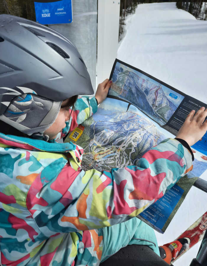 Reading the resort map while riding the chair lift.