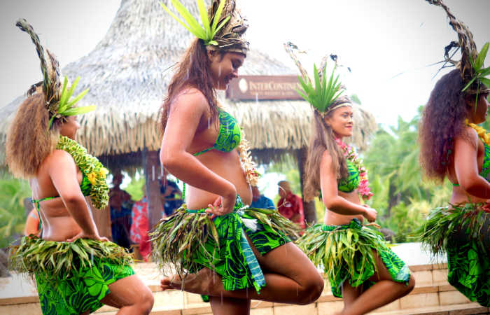 Four French Polynesia dancers in traditional green outfits. Photo by Kazuo ota on Unsplash