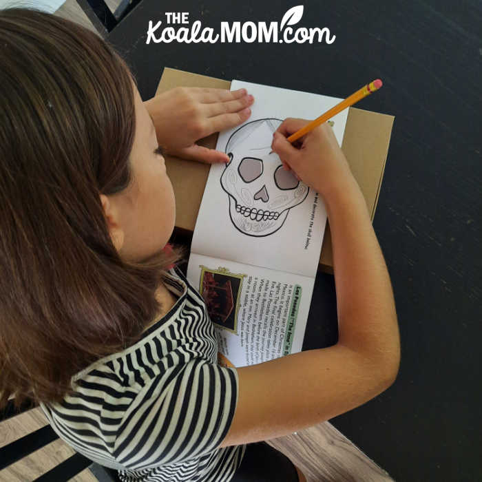 9-year-old girls decorates a Mexican sugar skull.