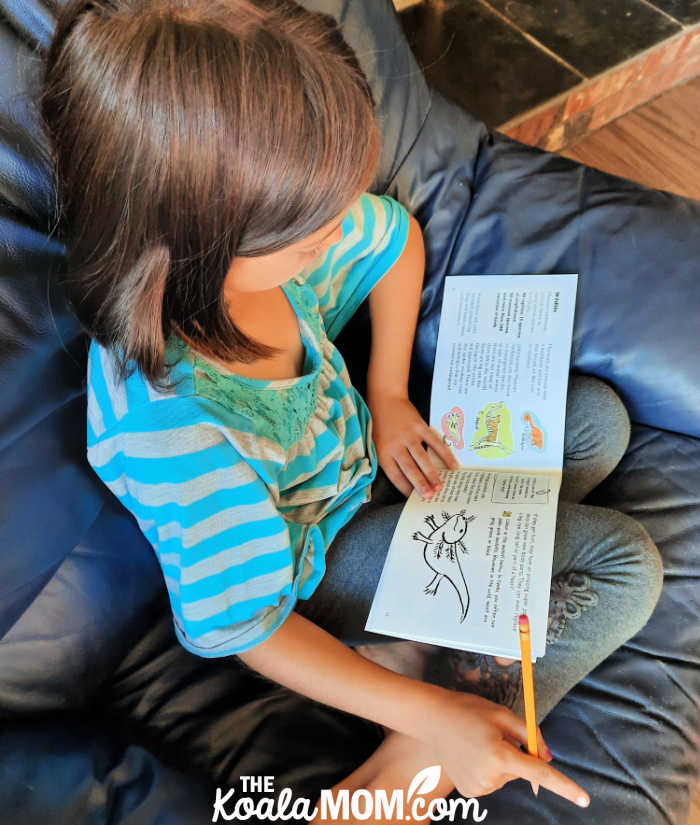 9-year-old girl reads about Mexico in a booklet from her World in a Box subscription.