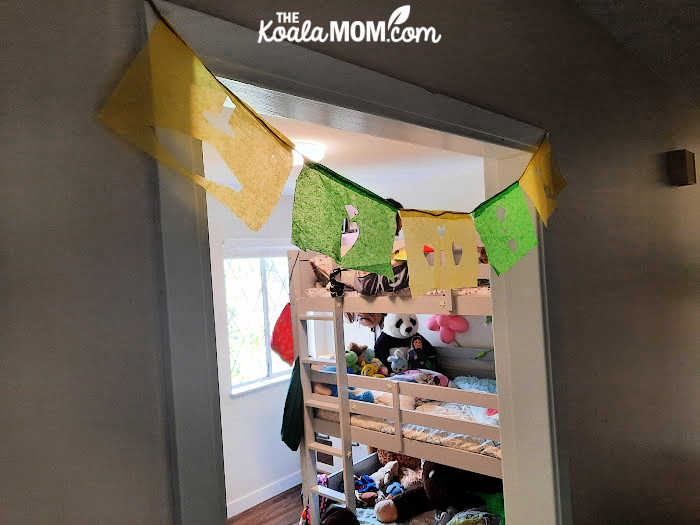 DIY papel picado banner hangs in a girl's bedroom doorway.