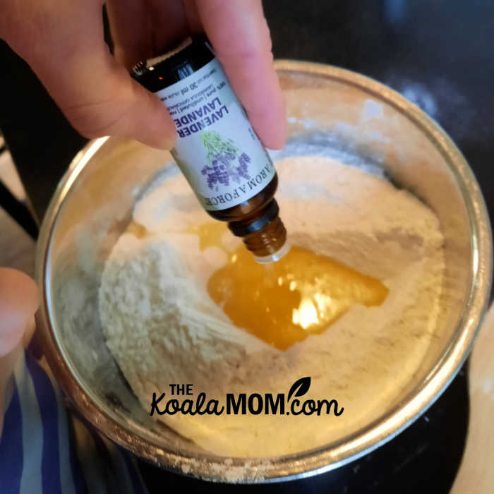 Mom adding a few drops of lavender essential oil to a homemade play dough batch.