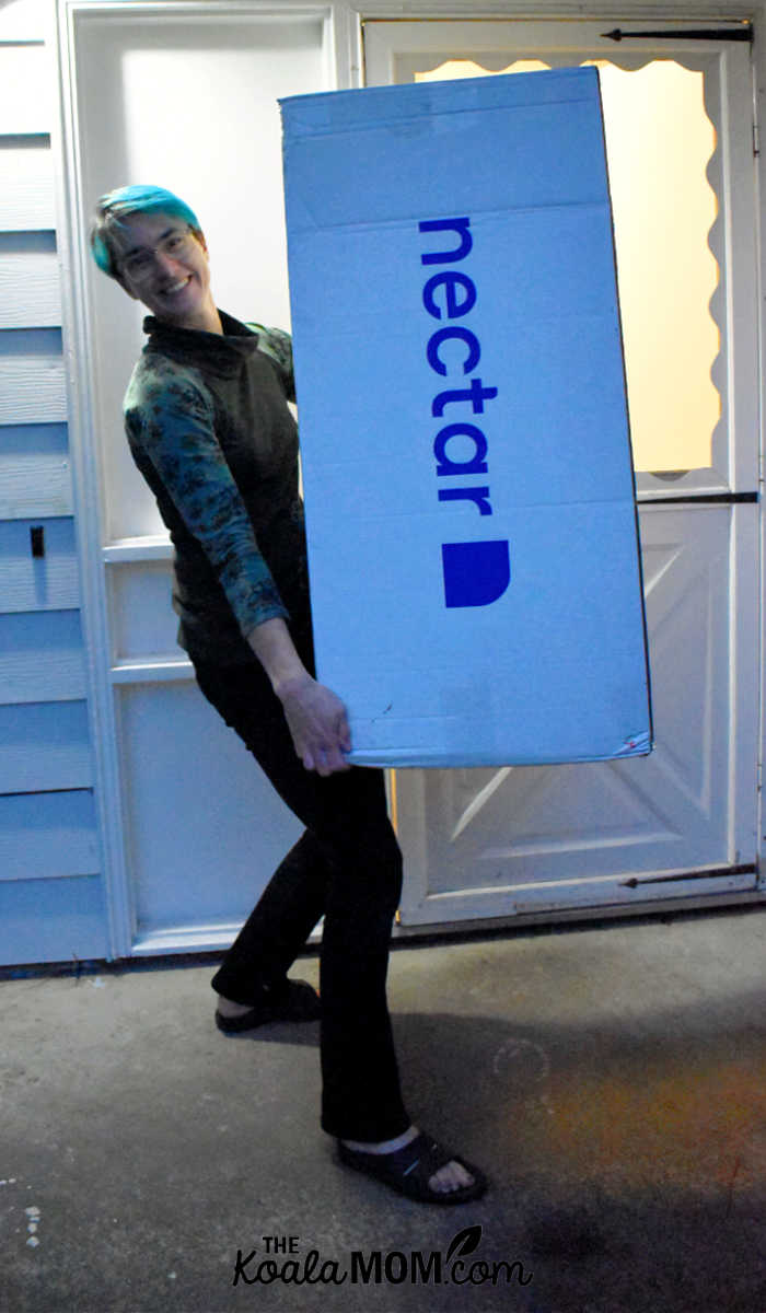 Bonnie Way carries her new Nectar twin-sized mattress into her house.