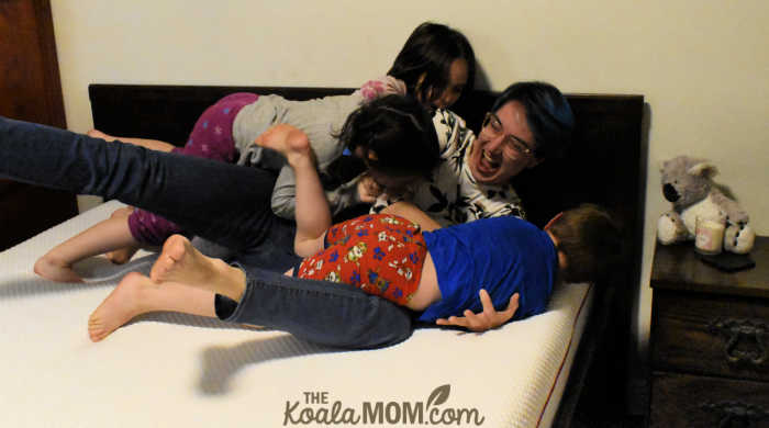 Mom and kids having a tickle fight on her Douglas original mattress.