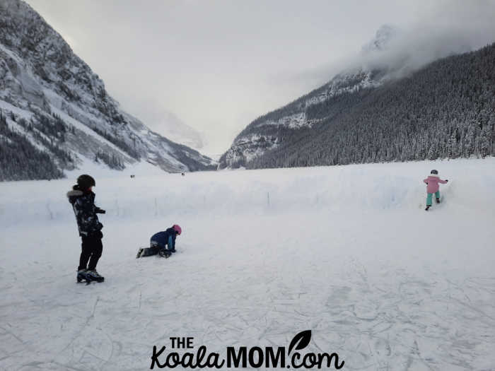 Three kids skating on the ice at Lake Louise.