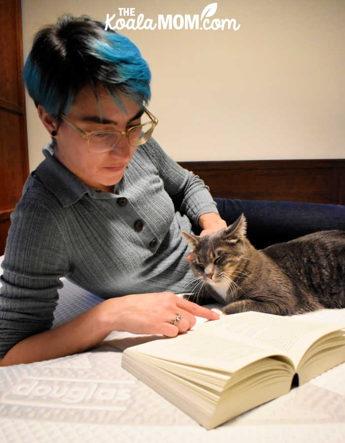 Mom reading a book with her cat on her Douglas original mattress.