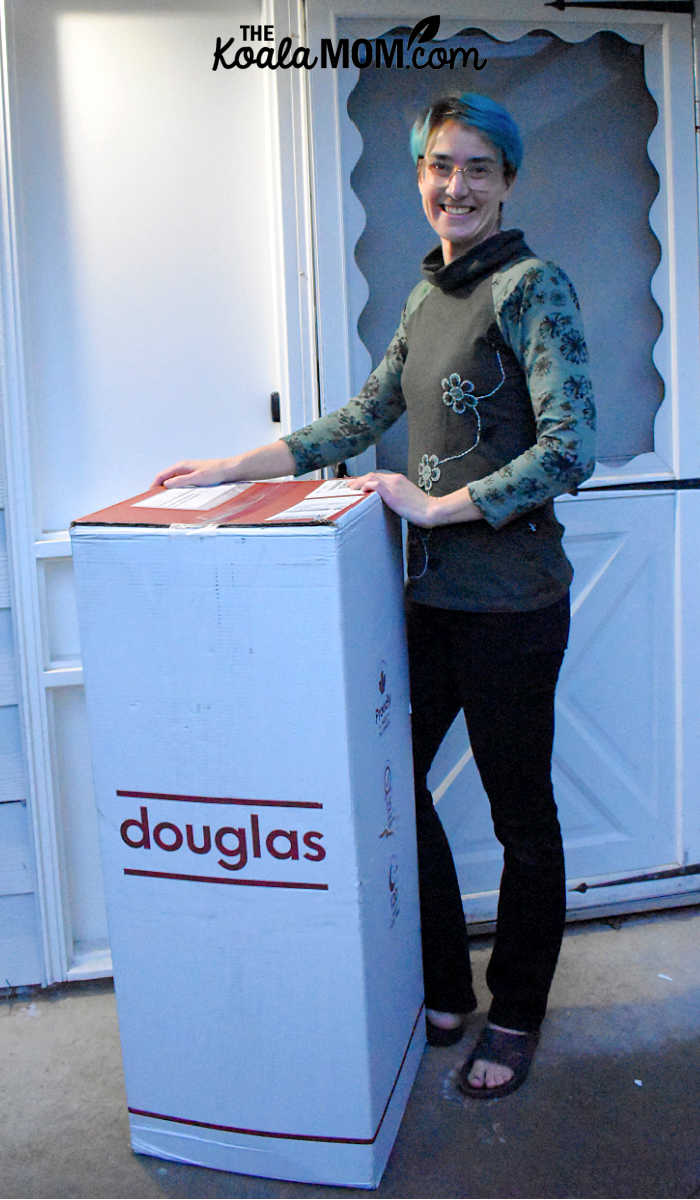 Bonnie Way standing beside her door with her new Douglas mattress-in-a-box.