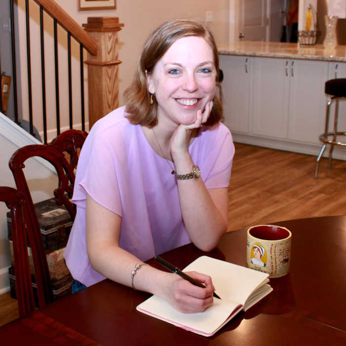 WAHM Taryn DeLong sits at her kitchen table writing in a planner.