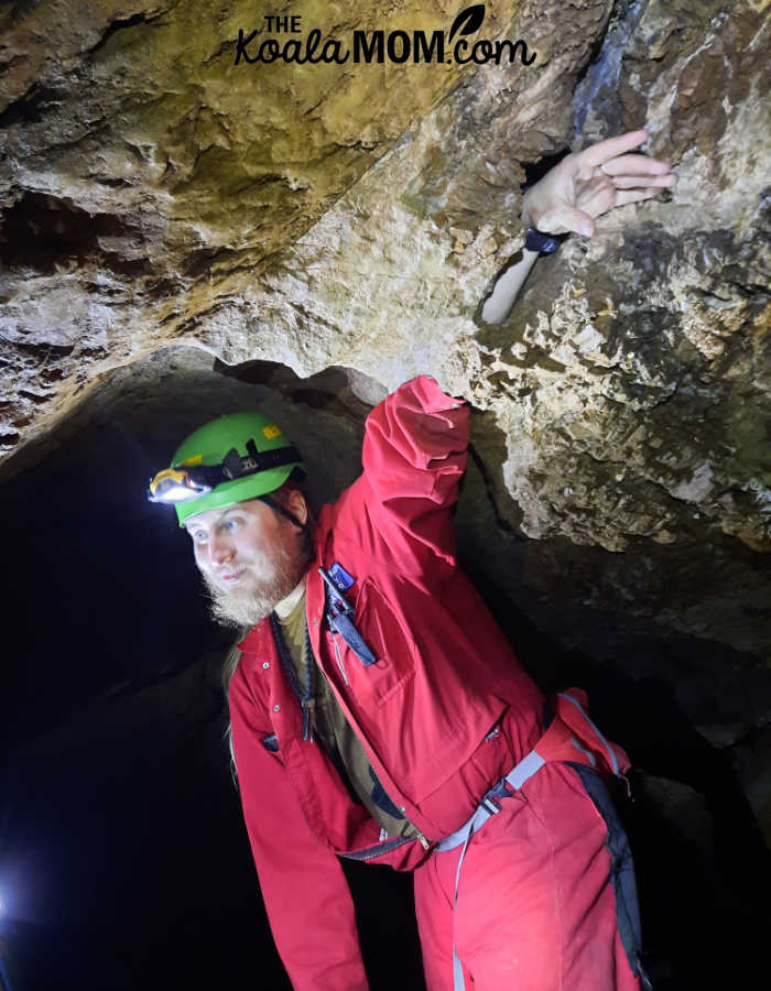 TJ puts his hand through a hole in the limestone roof of the cave.