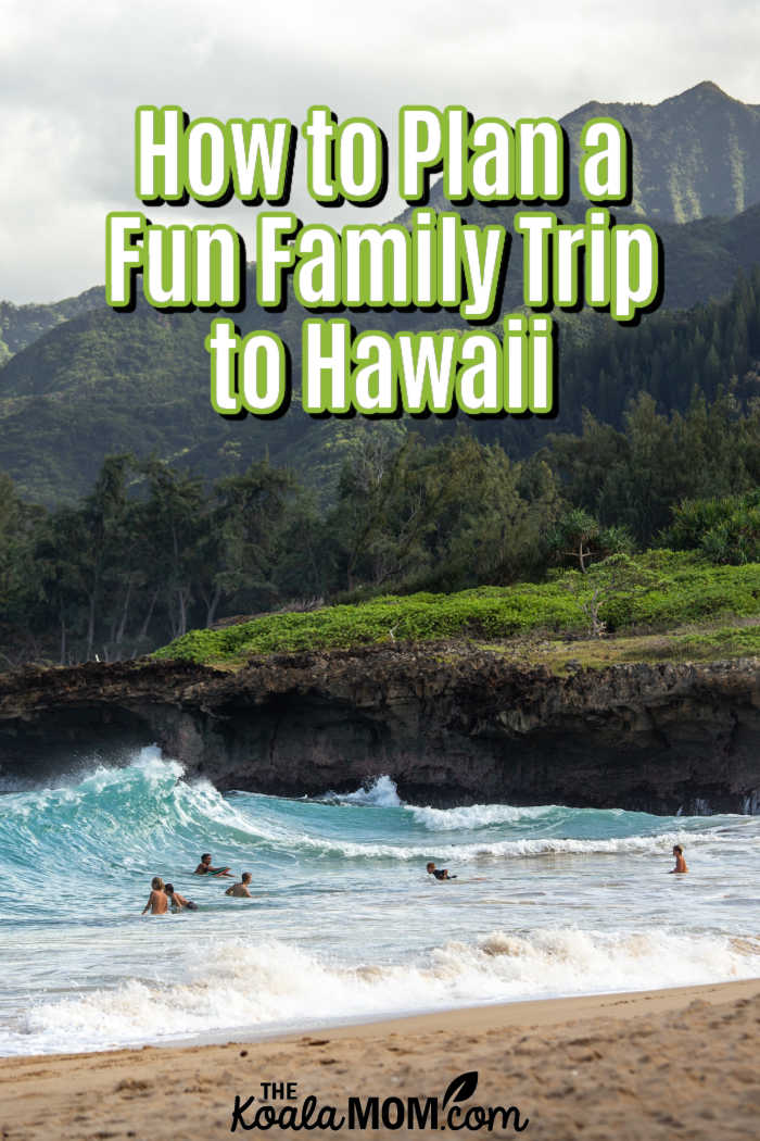 How To Plan A Fun Family Trip To Hawaii. Photo of people swimming on a beach in Hawaii with mountains above by Luke McKeown on Unsplash