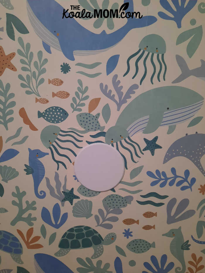 Ocean-themed wallpaper with a door stop on it.