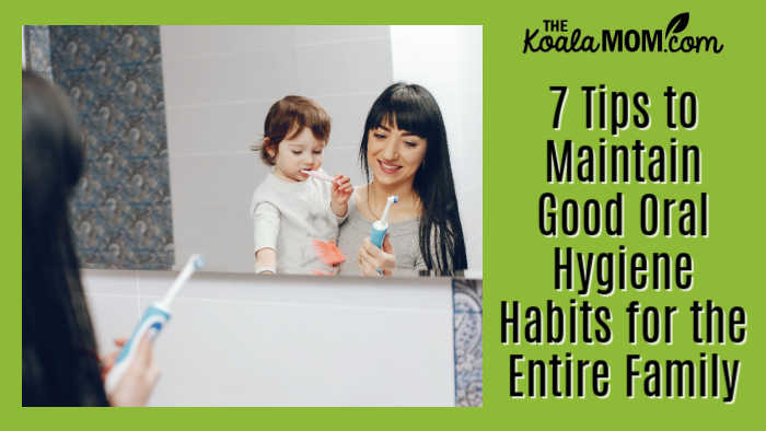 7 Tips to Maintain Good Oral Hygiene Habits for the Entire Family. Photo of mom holding her toddler on her hip while looking at her electric toothbrush by prostooleh via Freepik.