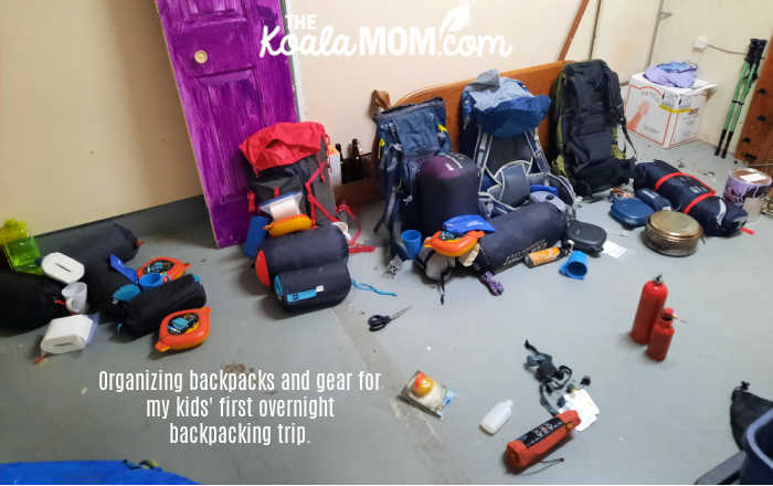 Backpacking gear and backpacks scattered around my garage as I prepare for my kids' first overnight backpacking trip.