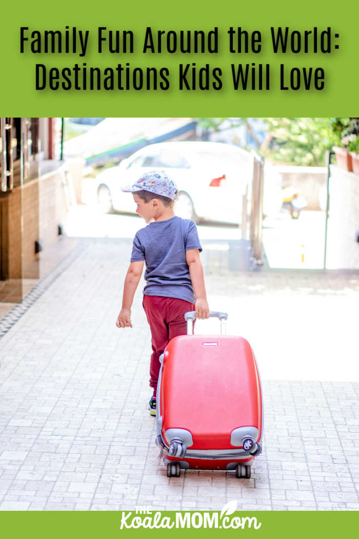 Family Fun Around the World: Destinations Kids Will Love. Photo of boy pulling a red wheelie suitcase while looking back over his shoulder towards camera by Atlantic Ambience via Pexels.