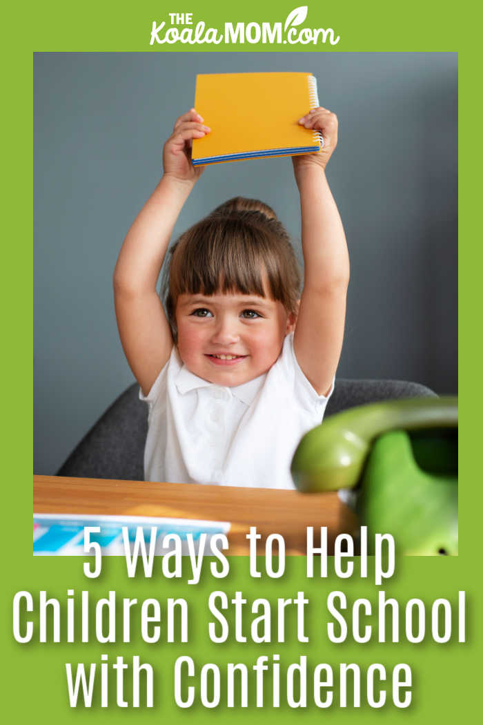 5 Ways to Help Children Start School with Confidence. Photo of smiling girl holding her notebook in the air by freepik.