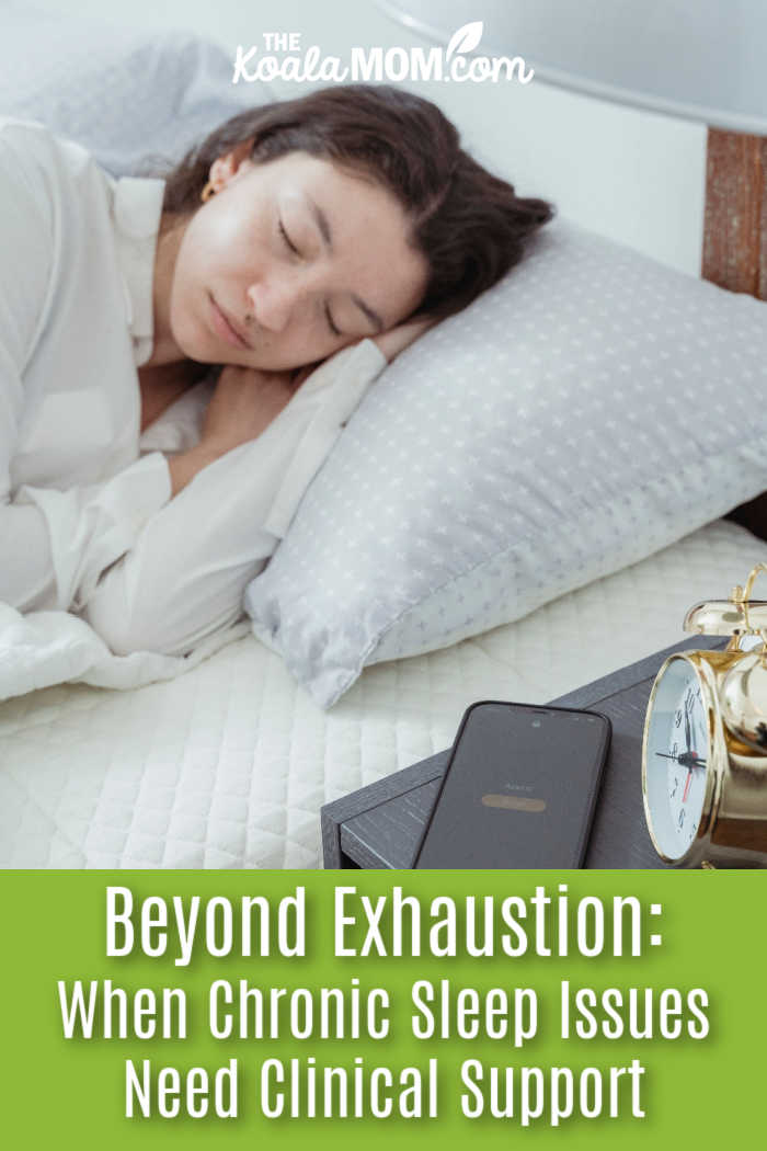 Beyond Exhaustion: When Chronic Sleep Issues Need Clinical Support. Photo of woman sleeping in a white bed with phone and alarm clock on bedside table by Miriam Alonso via Pexels.