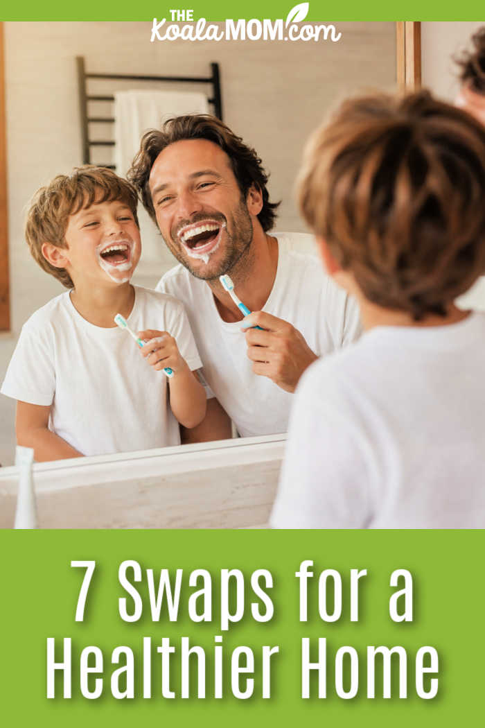 7 Swaps for a Healthier Home. Stock photo of father and son laughing at each other in bathroom mirror while brushing their teeth together.