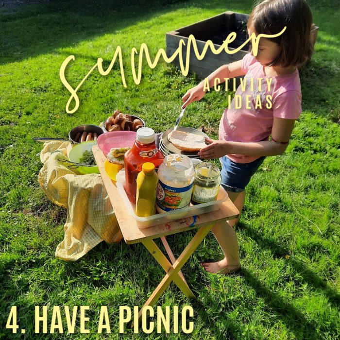 summer activity ideas 4. Have a picnic. Photo of a girl making a hog dog at a folding table on a lawn by Bonnie Way.