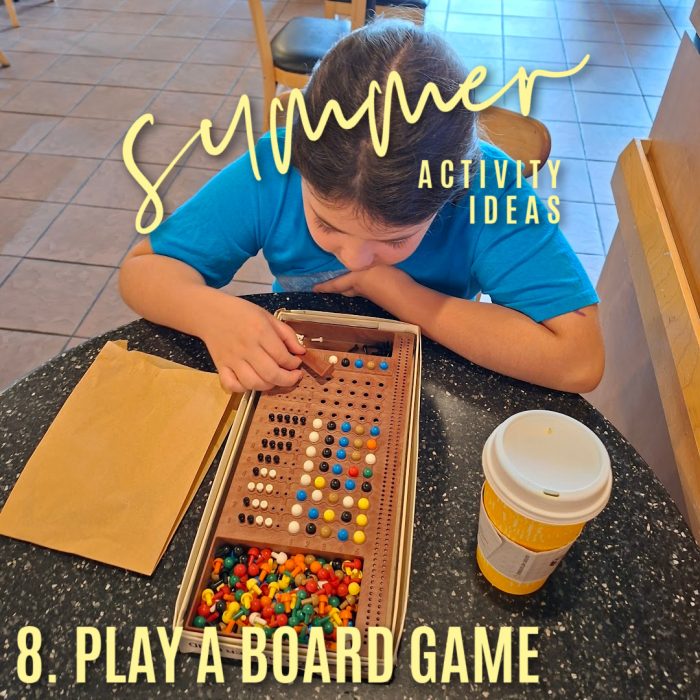 Summer activity ideas. 8. Play a board. Photo of a girl looking at a Mastermind game in a cafe by Bonnie Way.