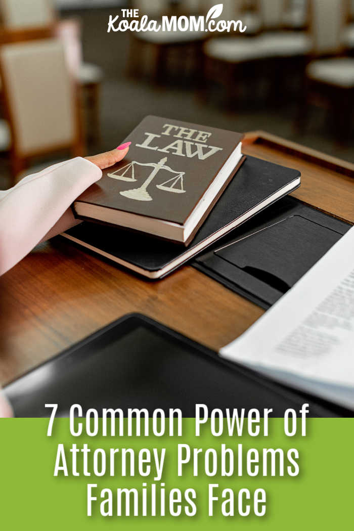7 Common Power of Attorney Problems Families Face. Photo of book saying "THE LAW" held over a desk with other folders on it by Mikhail Nilov via Pexels.