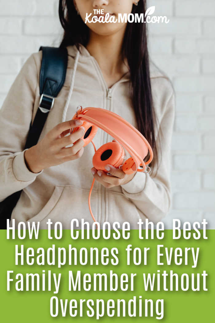 How to Choose the Best Headphones for Every Family Member without Overspending. Teenager in a casual hoodie holding orange headphones indoors against a white brick wall. Photo by https://kaboompics.com/ via Pexels.